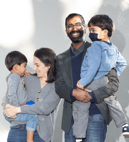 Shekar Krishnan and his wife Zoe Levine holding their two young boys